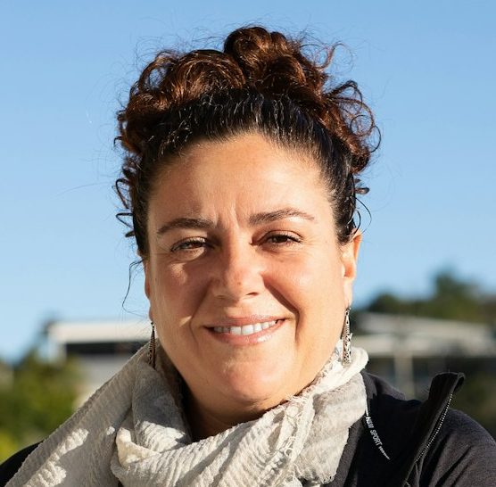 Latino Hispanic woman staying on the balcony on the sun, looking at camera and smiles